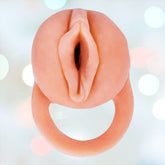 The Great Extender 2-in-1 Penis Extender & Masturbator by Nasstoys features a subtle design that mimics human anatomy, making it perfect for solo play, all set against a gentle bokeh background.